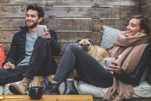 A man and a woman are sitting on the sofa laughing happily